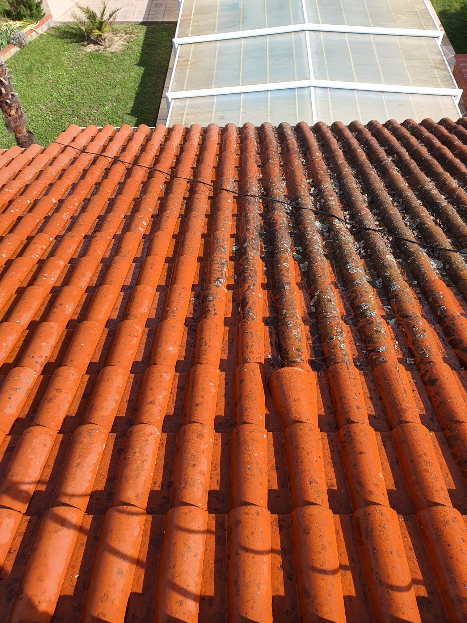 Toit en tuiles orange en cours de nettoyage