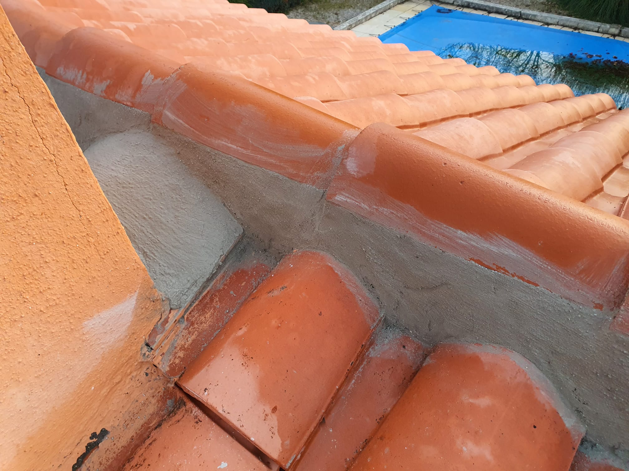 Toit en tuiles orange, angle visible.