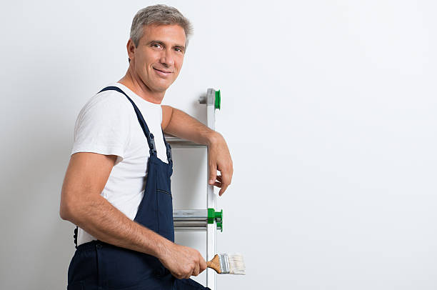 Homme avec échelle et pinceau.